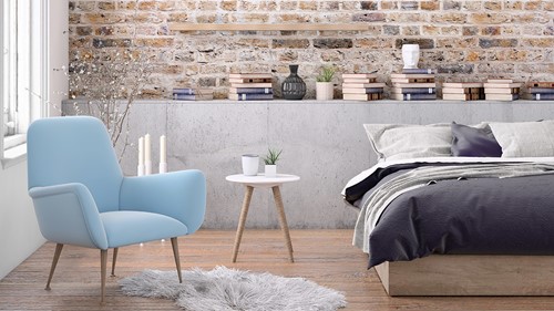 En interiör av ett möblerat sovrum i en lägenhet som visar en säng, fåtölj, krukor med växter etc.