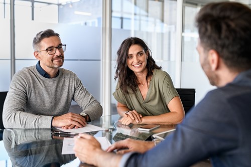 A couple discussing visa immigration requirements with an Alfa immigration consultant at the office.